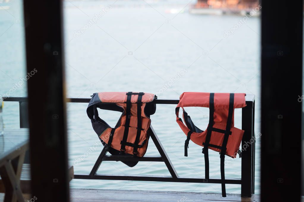 Life jacket hanging in floating hotel houses on dam at Thailand