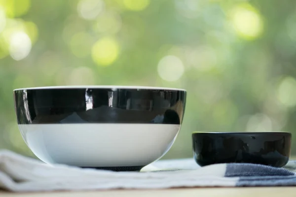Tigelas pretas e brancas em guardanapo na mesa — Fotografia de Stock