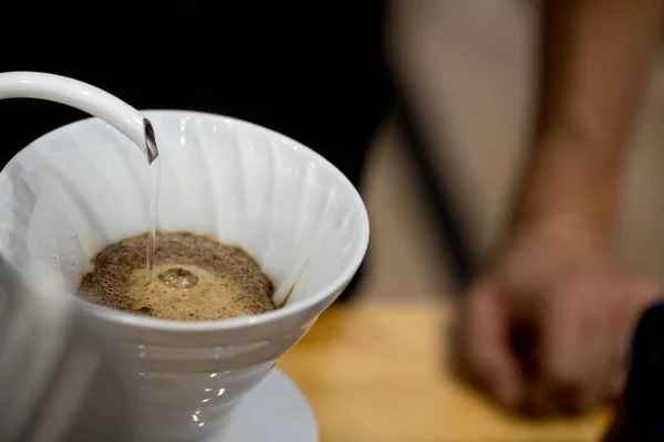 Homme versant de l'eau de la bouilloire dans le filtre à café . — Photo