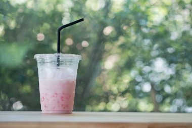 İçecek bittikten sonra plastik fincan ve saman buzlu pembe taze süt