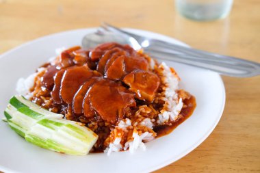 Ahşap masada pirinç ile sos mangalda kırmızı domuz eti.