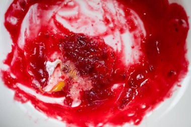 Beyaz çanak üzerinde Çilek reçel ile lekelenmiş