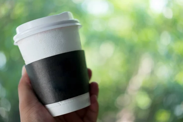 Mann hält Kaffeetasse zum Mitnehmen mit Papphülle — Stockfoto