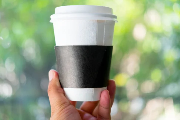 Mann hält Kaffeetasse zum Mitnehmen mit Papphülle — Stockfoto