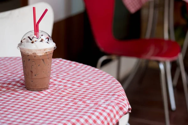 Chocolat glacé cacao et crème fouettée sur le dessus avec des tubes rouges — Photo