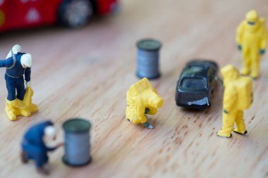 Arabanın yanında duran hazmat takım elbiseli itfaiyeci ekibinin figürü