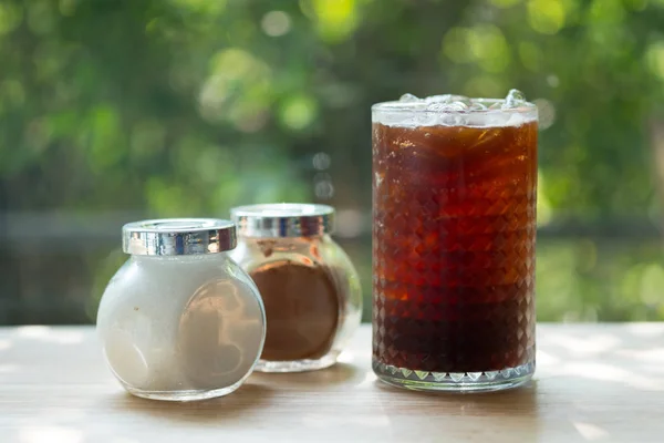 Kopi hitam dingin dengan gula dan gula coklat dalam botol kaca — Stok Foto