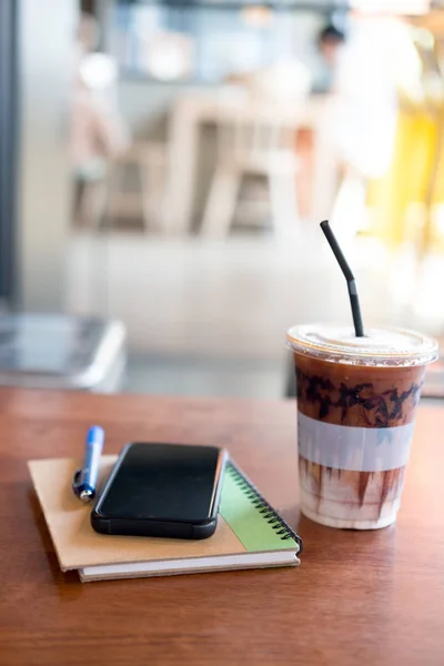 Workspace with iced coffee and smartphone, notebook on wood tabl — Stock Photo, Image