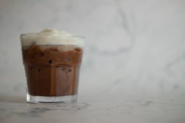 Mermer arka planda krem şanti ile koyu çikolata içecek 