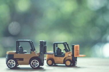 Ahşap masa üzerinde minyatür sarı forklift modeli 