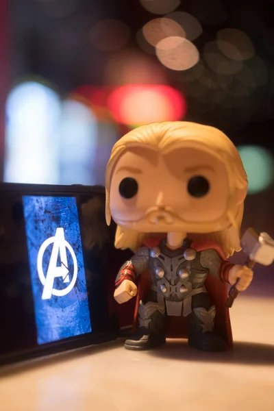 stock image Bangkok, Thailand - May 4, 2019 : Avengers Endgame logo on the mobile screen. Avengers: Endgame is a superhero movie produced by Marvel Studios and distributed by Walt Disney Studios Motion Pictures and Thor figures toy (Funko Pop! figures of Thor)