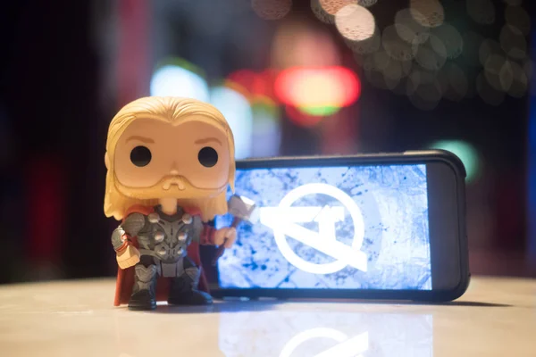 stock image Bangkok, Thailand - May 4, 2019 : Avengers Endgame logo on the mobile screen. Avengers: Endgame is a superhero movie produced by Marvel Studios and distributed by Walt Disney Studios Motion Pictures and Thor figures toy (Funko Pop! figures of Thor)