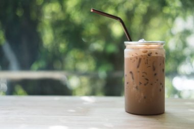 Kahve dükkanında ahşap masada açık plastik şişelerde buzlu mocha