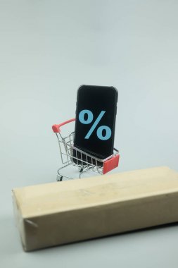 Alışveriş sepetinde ekranda indirim işareti olan akıllı telefon