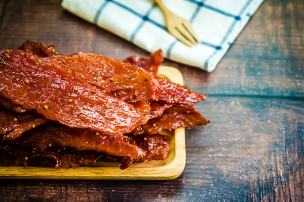 Ein Haufen Scheiben getrocknetes knuspriges Schweinefleisch — Stockfoto