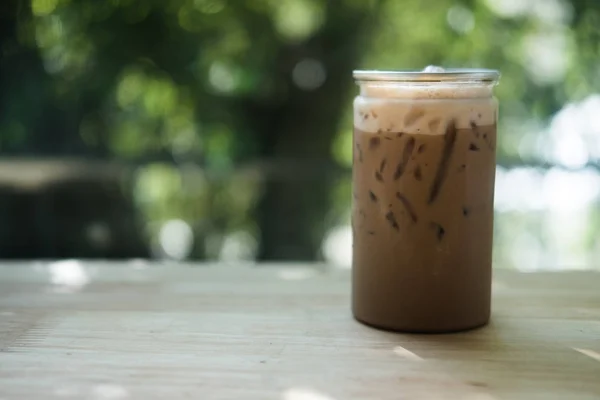 Iced mocha in clear plastic bottles on wood table in coffee shop