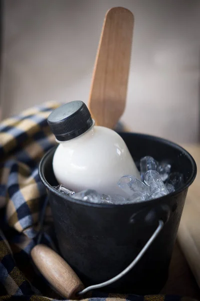 Palackban friss tejjel tálalva vödörben. — Stock Fotó