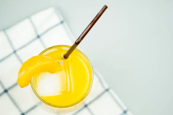 Taze sıkılmış tatlı portakal suyu buz küpleri ve dilim şeftali ile dekorasyon — Stok fotoğraf
