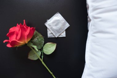 Kırmızı gül ve iki prezervatif