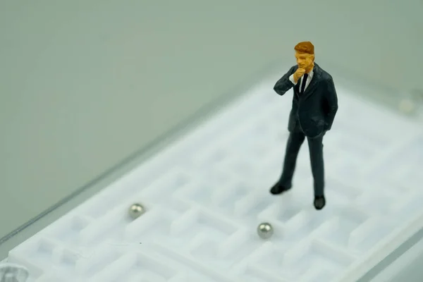 Persone in miniatura uomo d'affari in piedi su sfondo labirinto — Foto Stock