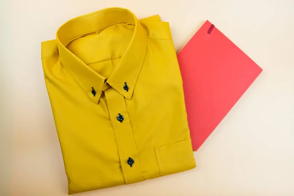 Mini cuaderno de papel rojo y camisa amarilla de hombre de negocios sobre fondo amarillo, vista superior —  Fotos de Stock