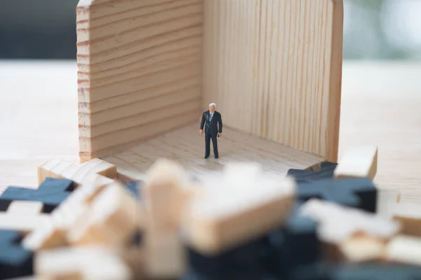 Мініатюрна людина бізнесмен стоїть за блоком — стокове фото