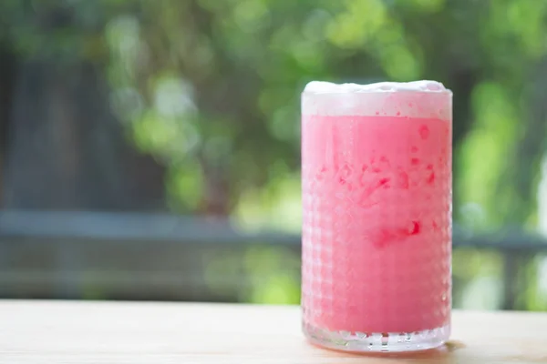 Pink milk iced in glass. Trendy drink.