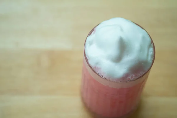 Lait rose glacé avec mousse de lait en verre . — Photo