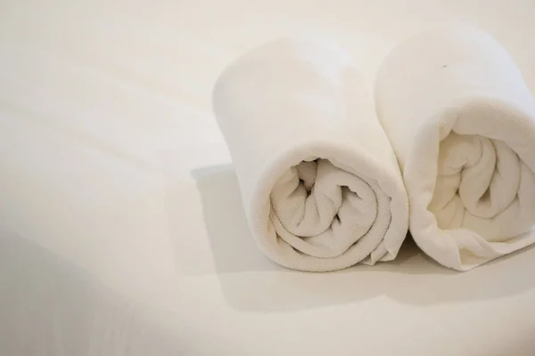 Rolka białego ręcznika na łóżku — Zdjęcie stockowe