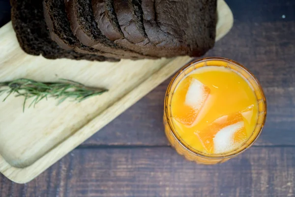 Fresco de suco de laranja com gelo servido com fatia de pão de chocolate — Fotografia de Stock