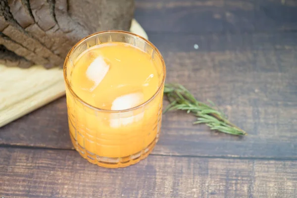 グラスにアイスキューブを入れた絞りたてのオレンジジュース — ストック写真