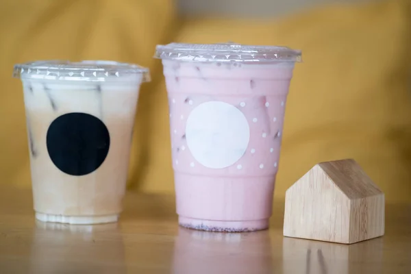 Café helado y leche fresca rosa helada en taza de plástico — Foto de Stock