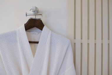 Duvarda askıda beyaz bornoz 