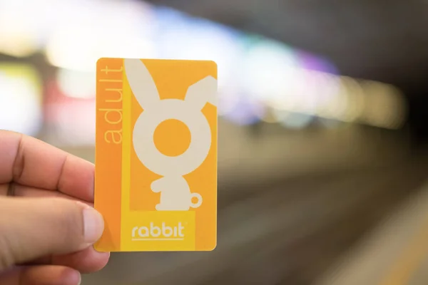 Bangkok, Tailandia - 12 de agosto de 2019: Commuter holding on to the Rabbit card for the cashless system for Bangkok 's BTS Sky Train. Skytrain es uno de los métodos más convenientes para viajar por Bangkok . — Foto de Stock