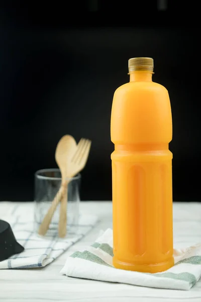 Cold orange juice bottles with gold lids