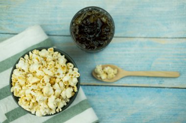 Ahşap arka plan üzerinde meşrubat ile fincan kase patlamış mısır.