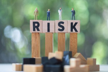 Minyatür adam grubu işadamları risk ile küp kelime üzerinde durmak. Yatırım için risk analizi. Kavram iş risk değerlendirmesi veya yönetim kavramı