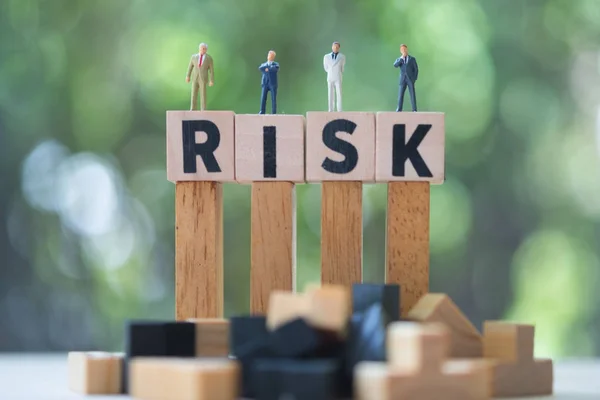 사업가의 미니어처 사람들 그룹은 위험이 큐브 단어에 서있다. 투자에 대한 위험 분석. 개념 비즈니스 위험 평가 또는 관리 개념 — 스톡 사진