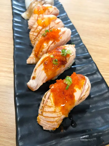 Conjunto de sushi de salmão coberto com molho doce e ovas de salmão — Fotografia de Stock
