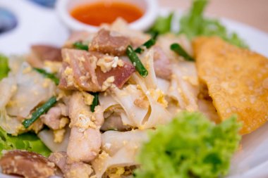 Tavuk, yumurta, kalamar ve marul ile karışık tavada kızarmış pirinç erişte ile yapılan Çin-Tay çanak. (Kuaitiao khua kai)