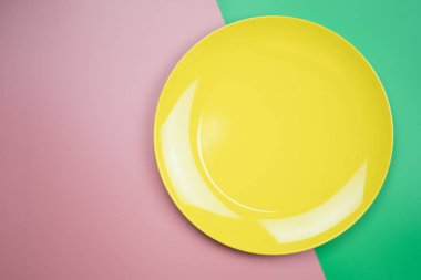 Pembe ve yeşil arka planda sarı yuvarlak plaka. 