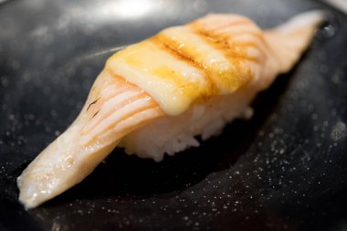 Siyah tabakta somon suşi yakmak