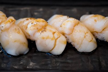 Japon Suşi - Hotate Nigiri Suşi (Tarak Suşi) siyah plaka üzerinde tatlı sos ile. Premium suşi