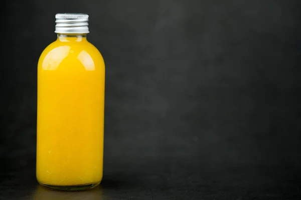 Small glass bottle of fresh orange juice. Vitamin concept.