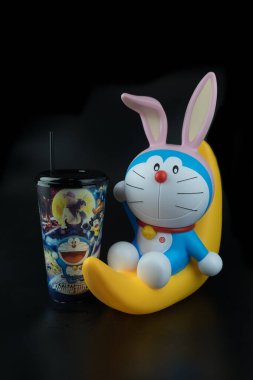 Bangkok, Tayland - 6 Ekim 2019: Doraemon 'un şirin oyuncağı yarım ayda oturuyor. Filmin tanıtımı için Major Cineplex Group Plc 'ten (Doraemon: Nobita' s Chronicle of the Moon Exploration) kova patlamış mısır ve meşrubat seti. Tayland 'da