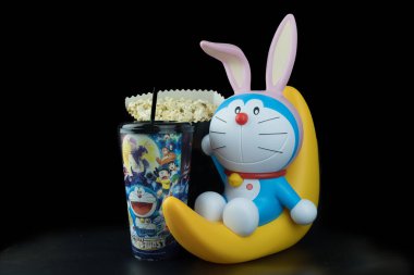 Bangkok, Tayland - 6 Ekim 2019: Doraemon 'un şirin oyuncağı yarım ayda oturuyor. Filmin tanıtımı için Major Cineplex Group Plc 'ten (Doraemon: Nobita' s Chronicle of the Moon Exploration) kova patlamış mısır ve meşrubat seti. Tayland 'da