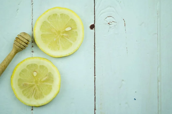 Rodajas de limón con palo de miel de madera — Foto de Stock