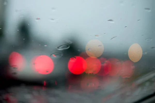 Desfocado fora de foco vista gotas de chuva no carro foco de vidro no caminho da estrada — Fotografia de Stock