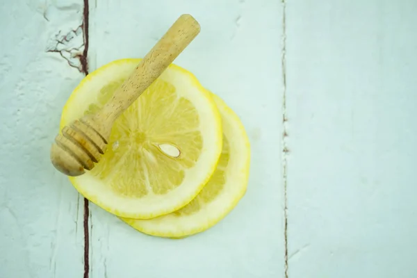 Palillo de miel de madera en rodajas de limón — Foto de Stock