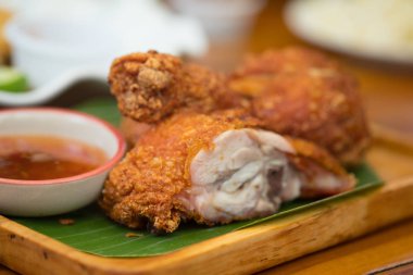 Ahşap tabakta kızarmış tavuk, tatlı sosla servis edilir.